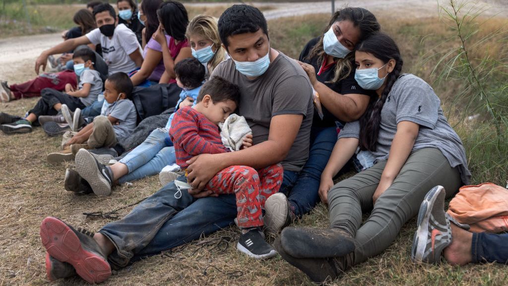 A Guatemalan family waits with fellow immigrants to board a U.S. Customs and Border Protection bus to a processing center after crossing the border from Mexico in La Joya, Texas, on April 13. A surge of immigrants, including record numbers of children, are making the arduous journey from Central America to the U.S., challenging immigration authorities. (John Moore/Getty Images)